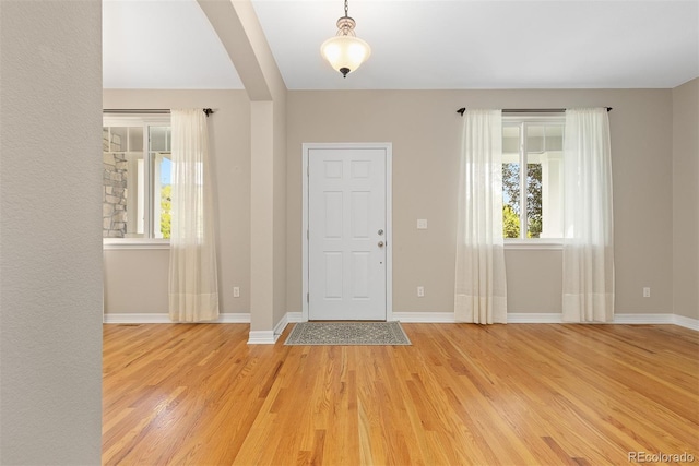 6520 S Newcastle Way, Aurora, CO 80016 - foyer featuring light wood-style flooring, baseboards, and arched walkways