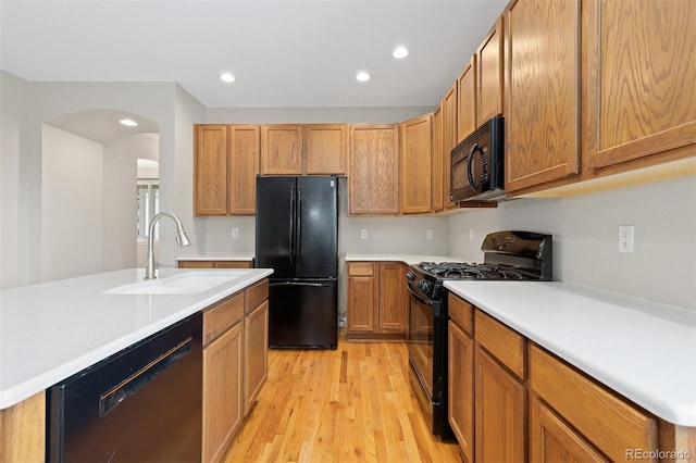 6520 S Newcastle Way, Aurora, CO 80016 - kitchen featuring black appliances, a sink, light wood-type flooring, light countertops, and recessed lighting