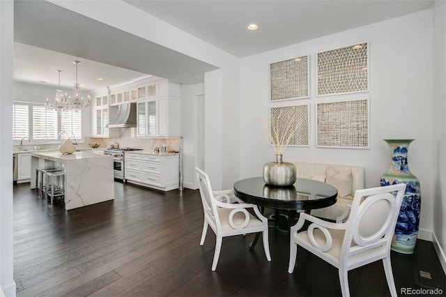 dining space with a chandelier, dark hardwood / wood-style floors, and sink