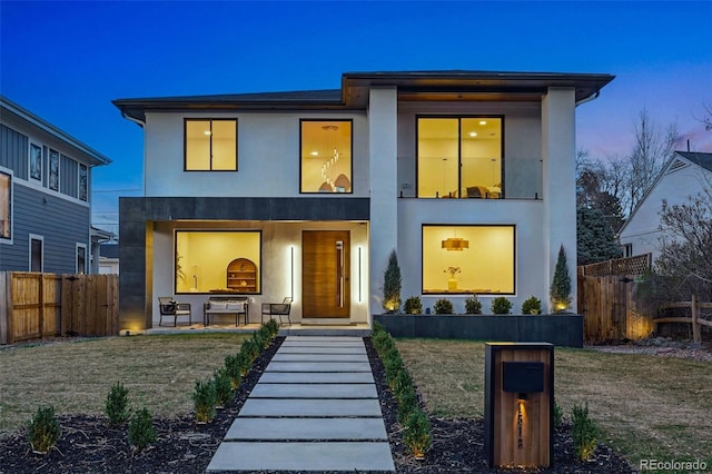 contemporary home featuring stucco siding and fence