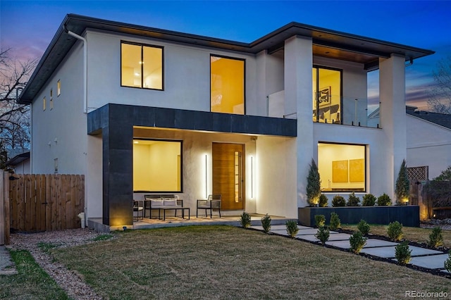 view of front of house featuring stucco siding, fence, and a patio area