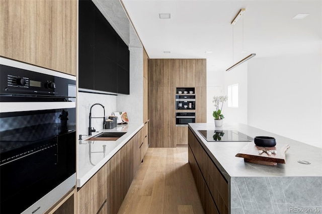 kitchen featuring a sink, modern cabinets, wall oven, and light countertops