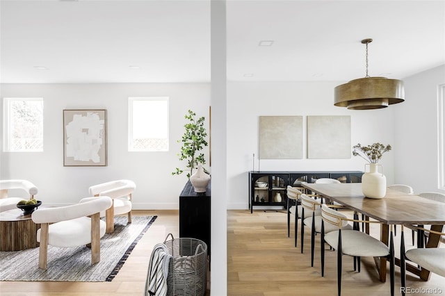 dining area featuring baseboards and light wood finished floors