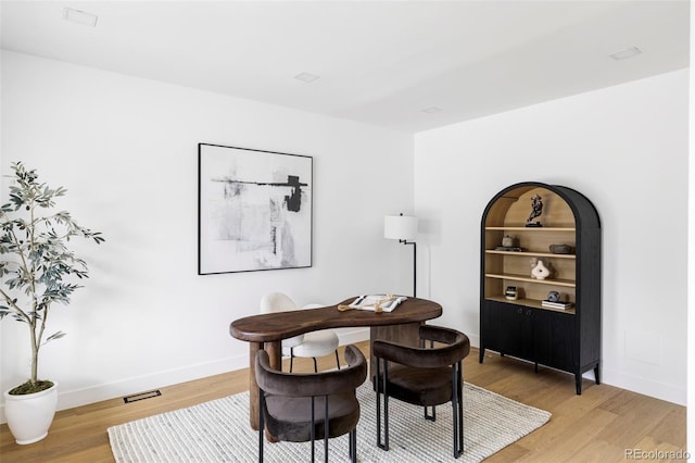 dining room featuring baseboards, visible vents, and light wood-type flooring