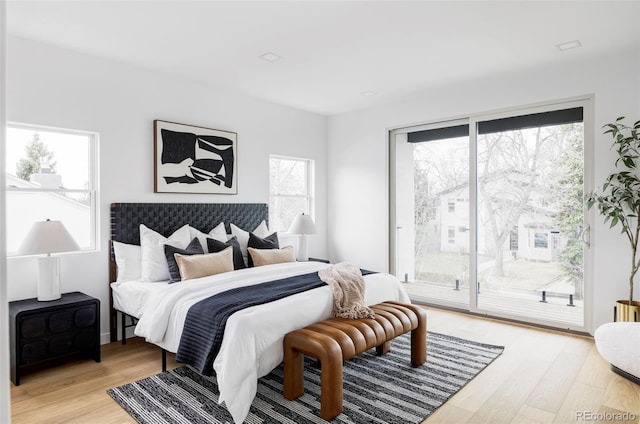 bedroom with light wood finished floors and access to exterior