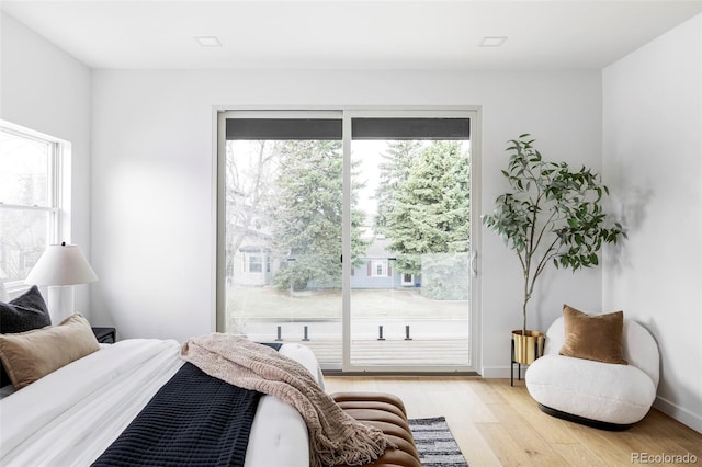bedroom featuring baseboards, access to outside, and light wood finished floors