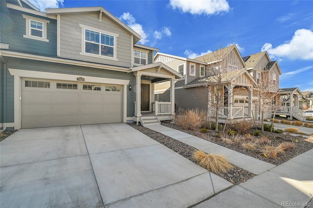 view of front of home with a porch, a residential view, concrete driveway, and an attached garage