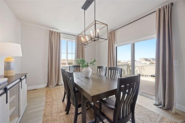 dining room featuring an inviting chandelier and baseboards