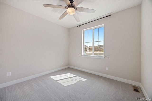 carpeted empty room featuring baseboards, ceiling fan, and visible vents