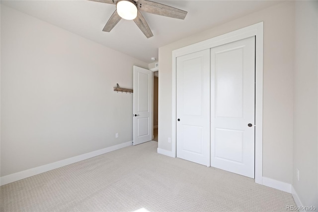 unfurnished bedroom featuring baseboards, a ceiling fan, a closet, and light colored carpet
