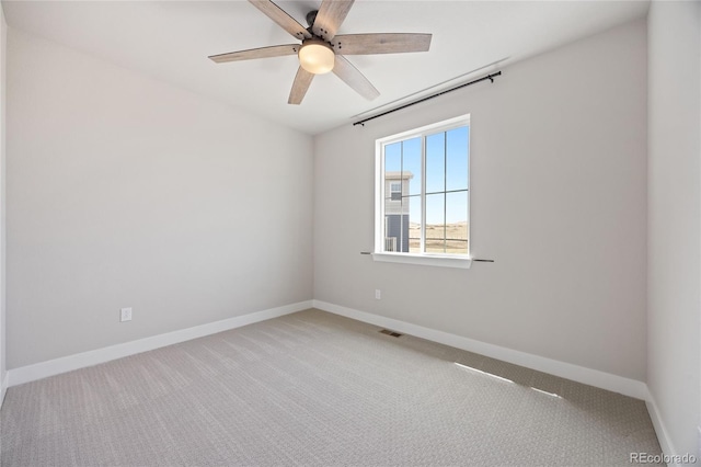 spare room with carpet floors, baseboards, and a ceiling fan