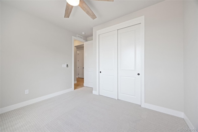 unfurnished bedroom with light colored carpet, baseboards, visible vents, and a closet