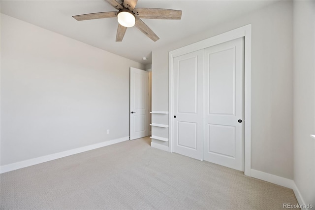 unfurnished bedroom featuring a ceiling fan, baseboards, light carpet, and a closet