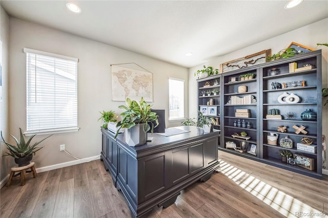 office space with recessed lighting, plenty of natural light, wood finished floors, and baseboards