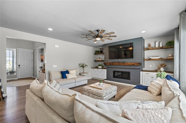 living room with dark wood-style floors, a glass covered fireplace, ceiling fan, and recessed lighting