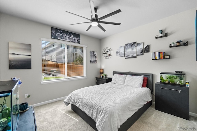 bedroom with baseboards, a ceiling fan, and light colored carpet