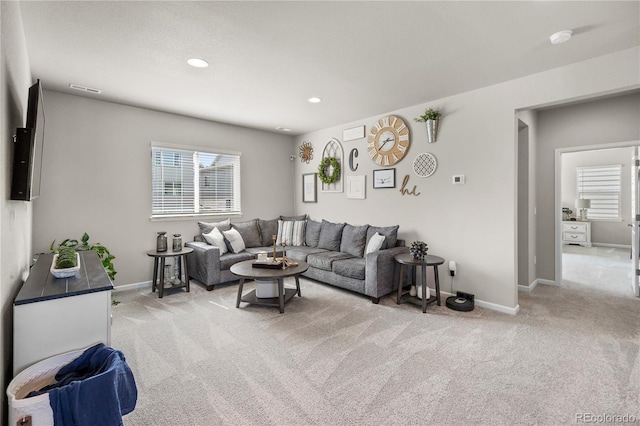 living area with recessed lighting, light colored carpet, and baseboards