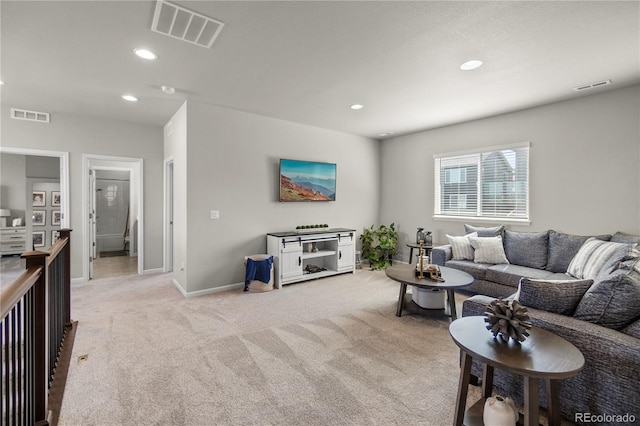 living area with recessed lighting, visible vents, and light carpet