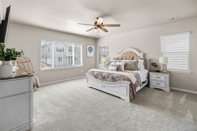 bedroom featuring a ceiling fan, light carpet, visible vents, and baseboards