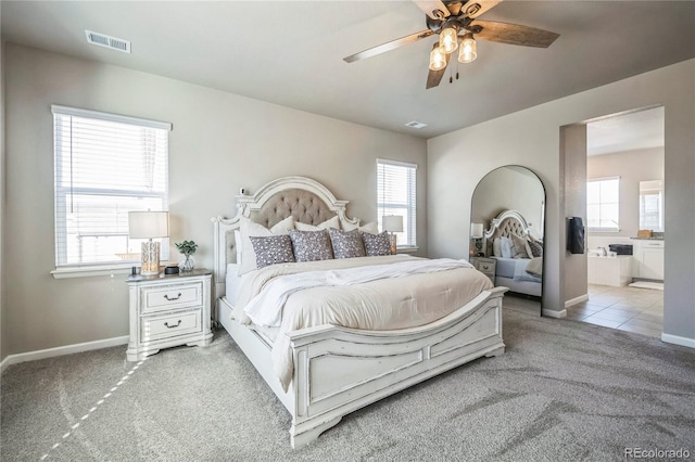 bedroom featuring light colored carpet, visible vents, baseboards, and multiple windows