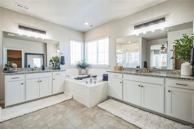 full bathroom with tile patterned flooring, a garden tub, two vanities, visible vents, and a stall shower