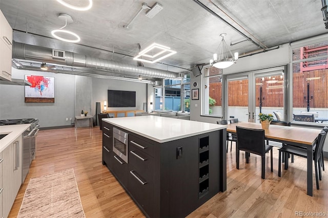 kitchen with a center island, light hardwood / wood-style floors, pendant lighting, and appliances with stainless steel finishes