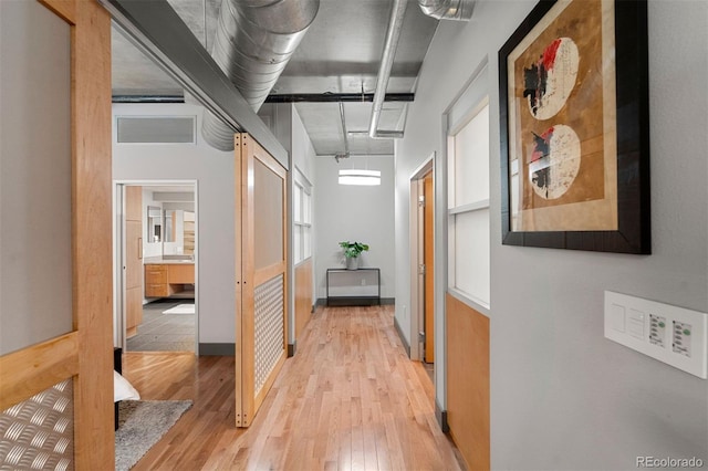 hallway with light hardwood / wood-style flooring