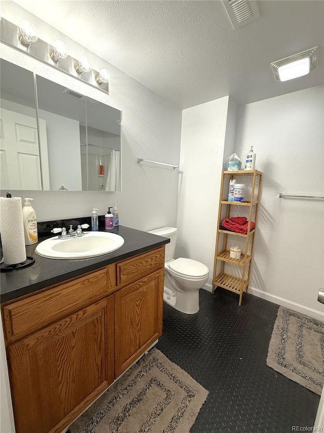 183 E Ave, Limon, CO 80828 - bathroom featuring vanity, toilet, tile patterned floors, and a textured ceiling
