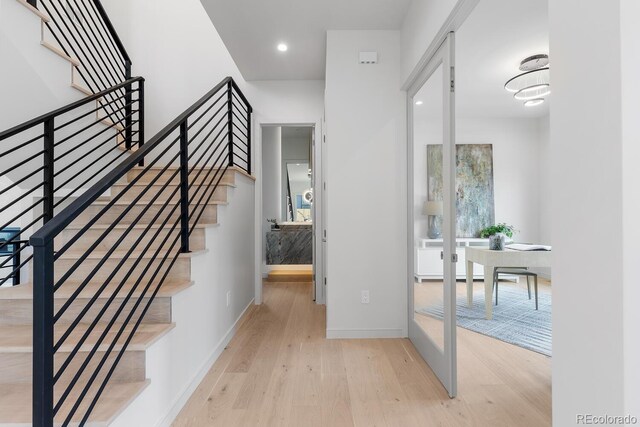 stairs featuring hardwood / wood-style floors, baseboards, and recessed lighting