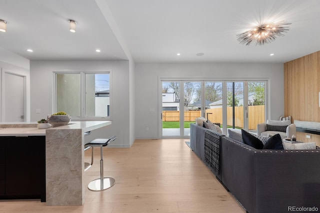 living room featuring recessed lighting, light wood finished floors, and baseboards