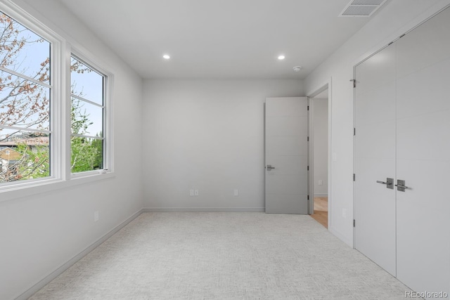 unfurnished bedroom featuring multiple windows, carpet, recessed lighting, and baseboards