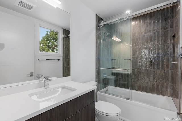 full bath with toilet, combined bath / shower with glass door, and vanity