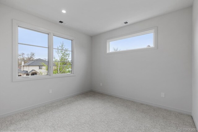 carpeted empty room with baseboards and recessed lighting