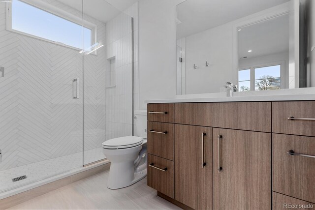 full bath with toilet, plenty of natural light, a shower stall, and vanity