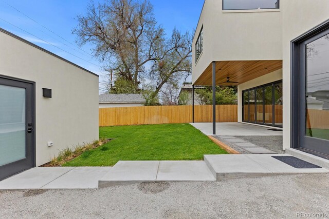 view of yard featuring a patio area and ceiling fan
