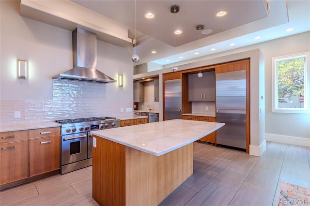 kitchen with decorative backsplash, high quality appliances, modern cabinets, and wall chimney exhaust hood
