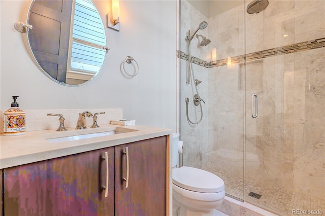 bathroom with toilet, vanity, and a shower stall