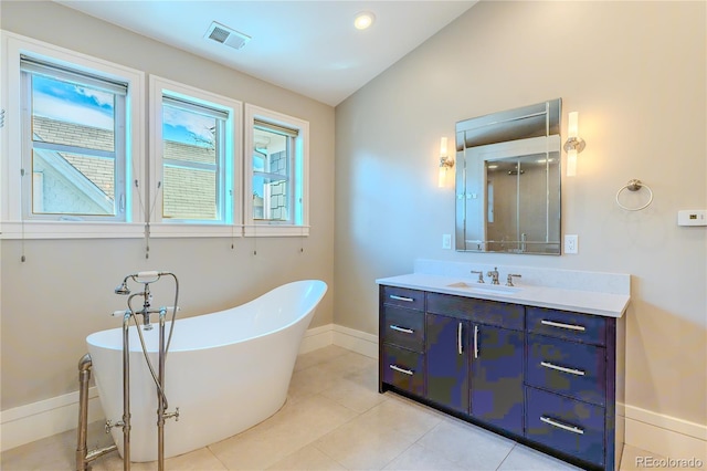 bathroom featuring lofted ceiling, baseboards, visible vents, vanity, and a freestanding bath