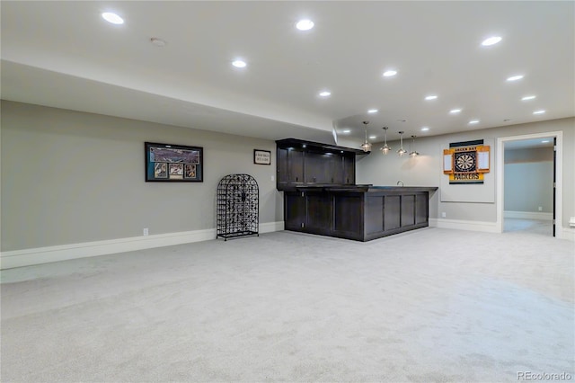 finished below grade area with light carpet, wet bar, baseboards, and recessed lighting
