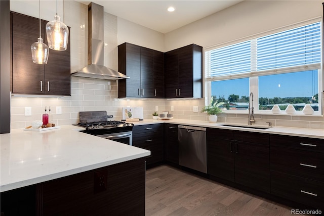 7861 W 51st Ave Unit B, Arvada, CO 80002 - kitchen with wall chimney exhaust hood, stainless steel appliances, light countertops, light wood-style floors, and recessed lighting
