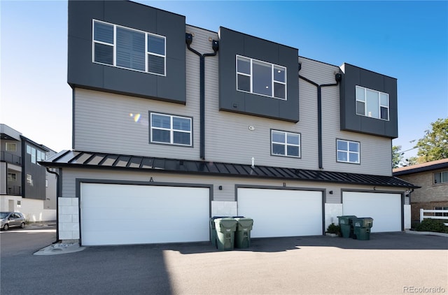7861 W 51st Ave Unit B, Arvada, CO 80002 - view of front of house featuring a standing seam roof, an attached garage, a metal roof, and driveway