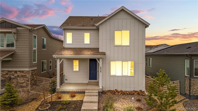 8028 Williams Fork Ave, Littleton, CO 80125 - view of front of house featuring board and batten siding, roof with shingles, covered porch, and stone siding