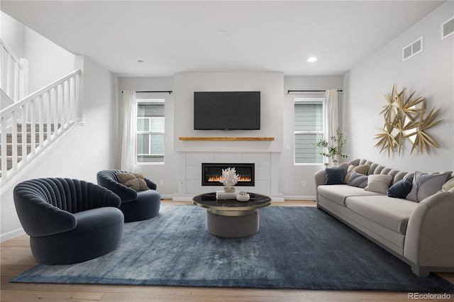 8028 Williams Fork Ave, Littleton, CO 80125 - living area featuring stairway, a glass covered fireplace, wood finished floors, and recessed lighting