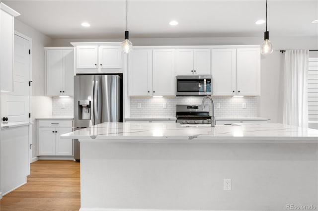 8028 Williams Fork Ave, Littleton, CO 80125 - kitchen featuring stainless steel appliances, white cabinetry, light wood-type flooring, and recessed lighting