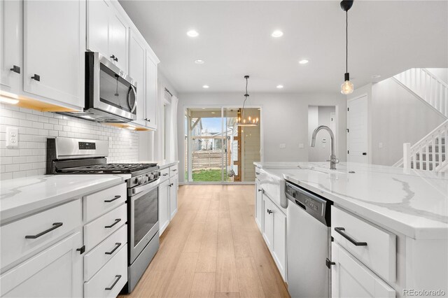 8028 Williams Fork Ave, Littleton, CO 80125 - kitchen featuring stainless steel appliances, recessed lighting, decorative backsplash, white cabinetry, and light wood finished floors