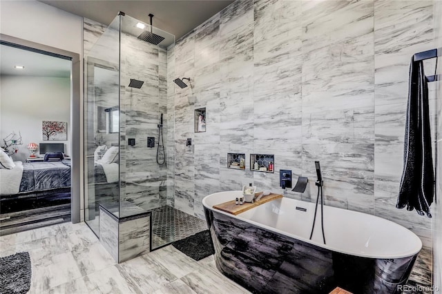 ensuite bathroom featuring ensuite bathroom, tile walls, a freestanding bath, marble finish floor, and a stall shower