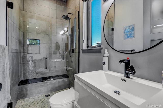 bathroom featuring a shower stall, toilet, and vanity