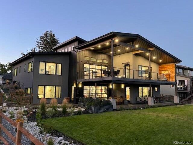 rear view of house with a lawn, a patio area, a balcony, and a ceiling fan