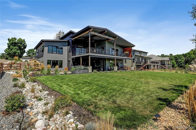 back of property featuring a yard, fence, a deck, and stucco siding