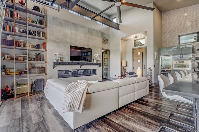 living room with dark wood-style flooring and a towering ceiling